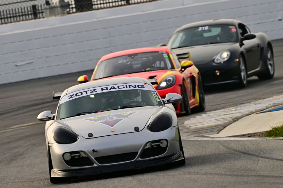 Porsche Cayman leading a train of cars through a chicane