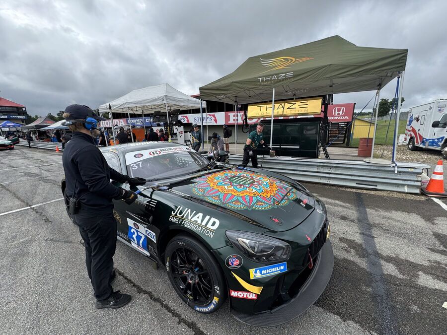 GT4 car rolling to the grid under a canopy